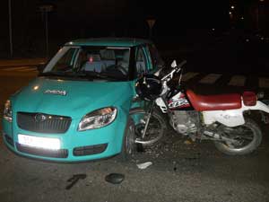A motorcycle crashed into the side of a car.