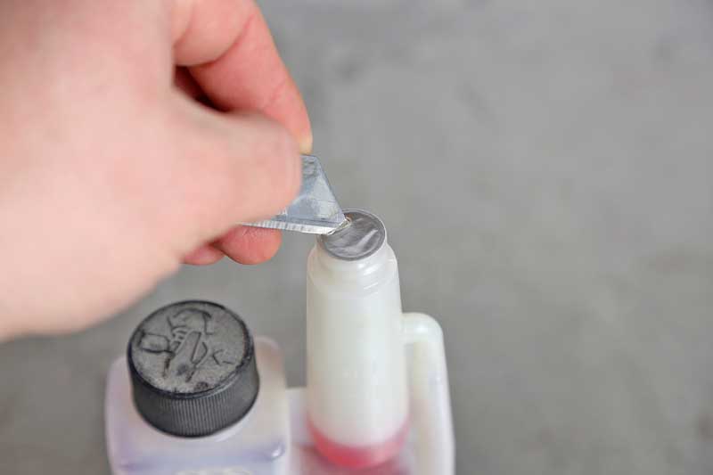 Pull the cap on the small spout and remove the seal.