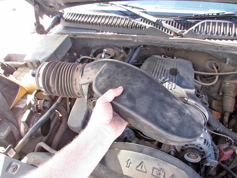 First, the air box and air inlet hose are removed to expose the upper radiator shroud. 