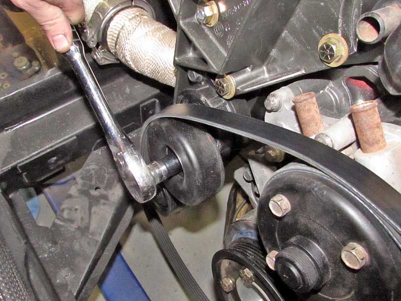 Using a ratchet and socket (some tensioners do not require a socket, just the ratchet head), release the tension and hold in place.